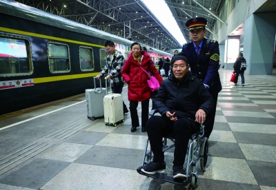 南京客运段工作人员帮助行动不便的旅客上车。