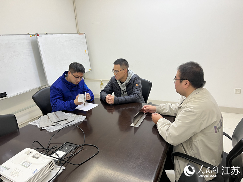 张涛(中)和企业沟通技术细节。人民网 江楠摄